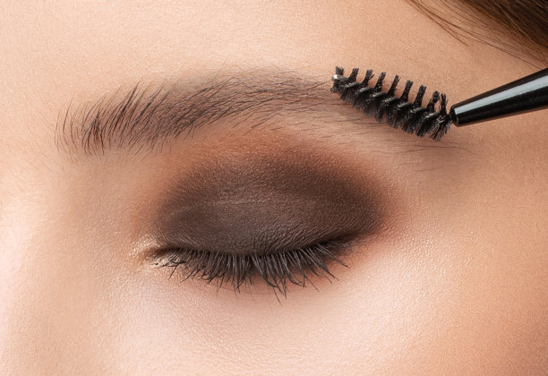 化妆师在美容院梳和拔眉毛。专业化妆美容护肤。图片下载