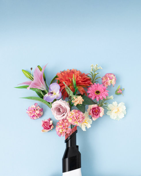 创意概念真空吸尘器就像一个花瓶，里面有五颜六色的鲜花。平铺在柔和的蓝色背景上。“n图片下载