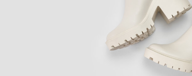 时尚的米色皮革女性靴子与浅灰色背景上粗糙的鞋底顶视图。流行的春秋鞋。创意简约的鞋子背景。与鞋类模型布局图片下载