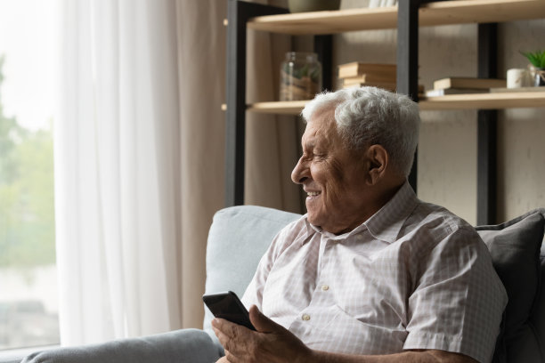 兴高采烈的80多岁老人戴着眼镜，拿着手机，图片下载