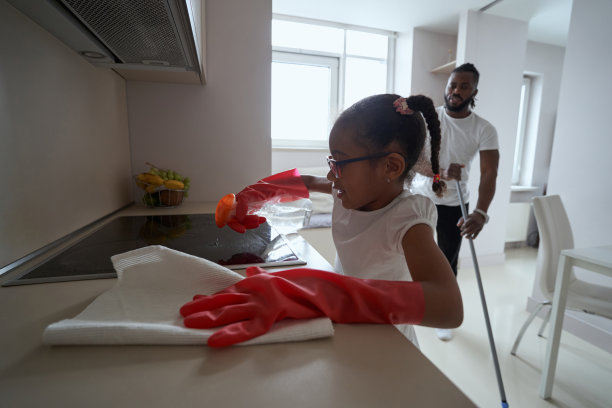 小女孩勤奋地和爸爸一起打扫厨房图片下载