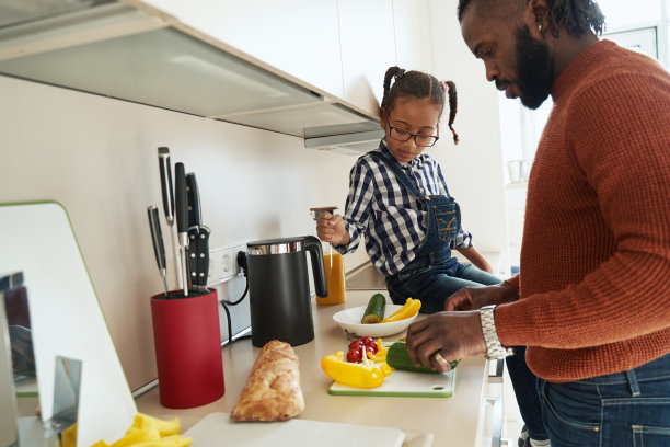 体贴的小女孩在厨房帮父亲干活图片下载