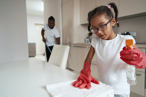 小女孩戴着手套小心翼翼地擦桌子图片下载