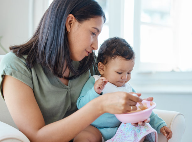 一张母亲坐在椅子上喂孩子的照片图片下载