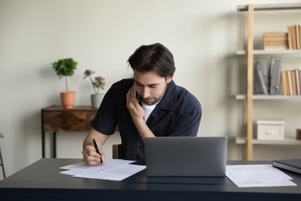 非常忙碌的商务专业人士在笔记本电脑上用手机谈判图片下载