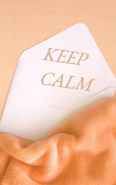 保持冷静，文本在白色信封上米色柔和的背景与折叠蓬松的毯子图片下载