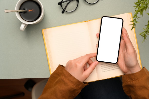 头顶照片，女性的手在办公桌上使用智能手机图片下载