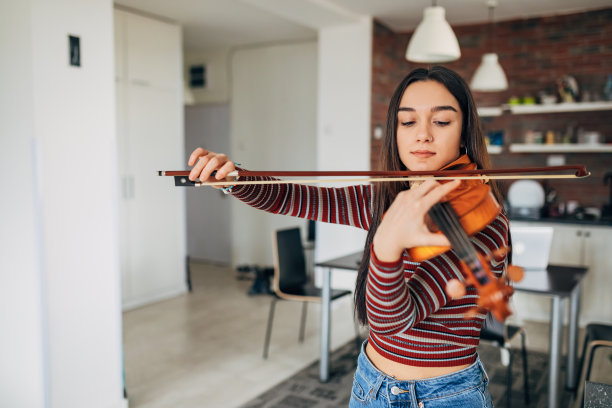一位年轻女子正在努力成为一名成功的小提琴家和艺术家。图片下载