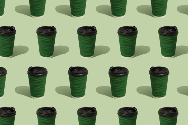 图案与生态纸绿色咖啡杯在绿色背景，模型图像。可持续食品包装理念图片下载