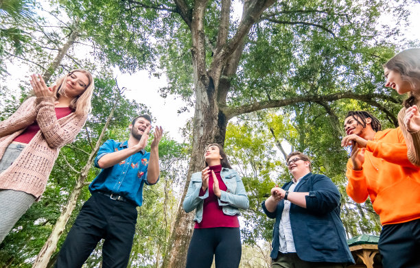 各种各样快乐的年轻人在户外欢笑、鼓掌、唱歌，青年团或俱乐部或团队建设图片下载