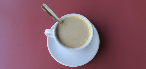 一杯牛奶咖啡在红色的背景上。图片下载