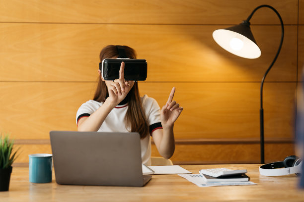 美丽微笑的女孩戴上VR头显和空中互动触摸。VR头戴眼镜设备。亚洲女商人被虚拟现实控制。图片下载