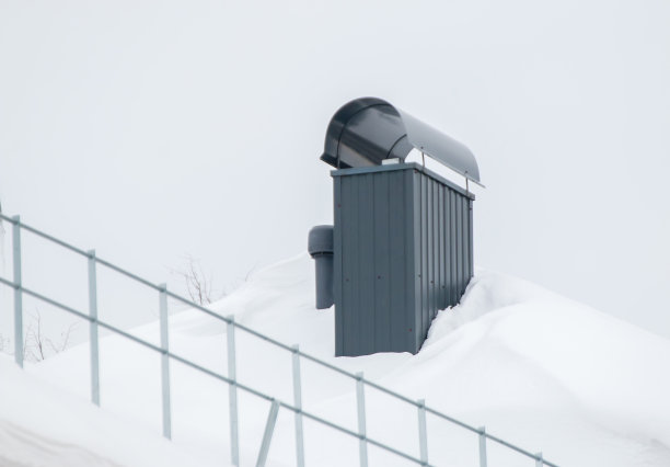 优雅的矩形金属烟囱在屋顶上的房子。图片下载