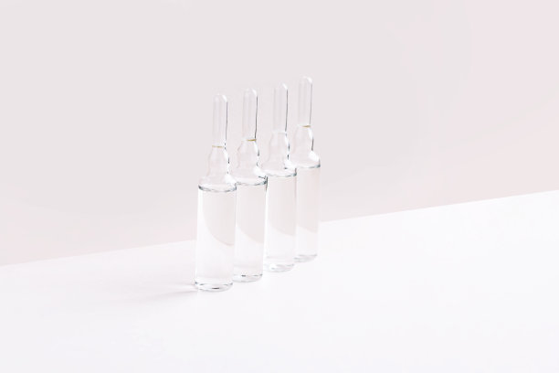 在粉红色时尚的背景上为头发治疗安瓿瓶。时尚简约主义图片下载