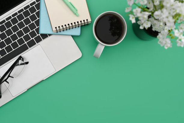 以上查看笔记本电脑，咖啡杯，笔记本电脑和花盆在绿色的背景。图片下载