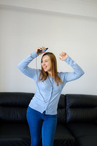 跳舞的女人用智能手机和耳机听音乐图片下载