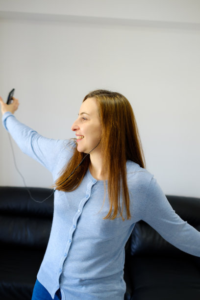 跳舞的女人用智能手机和耳机听音乐图片下载