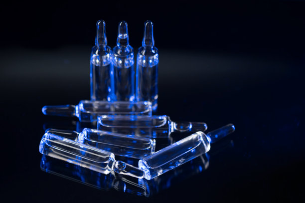 黑色光滑的桌子上放着注射用的医用安瓿图片下载