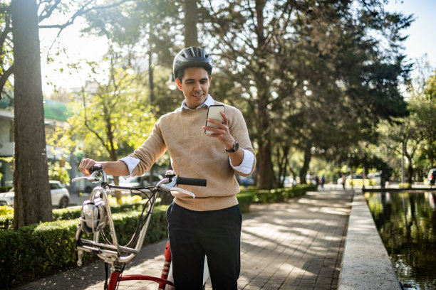 年轻人推着自行车，用着手机图片下载