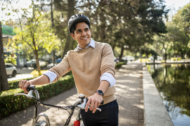 一个年轻人推着自行车穿过公园图片下载