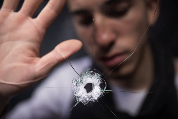 年轻男人手扶着被撞裂的玻璃图片下载