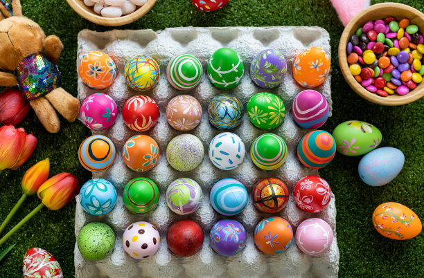 复活节假期概念，彩蛋盒，篮子复活节彩蛋，糖果篮子，兔子娃娃在绿色草地的背景与空间。图片下载