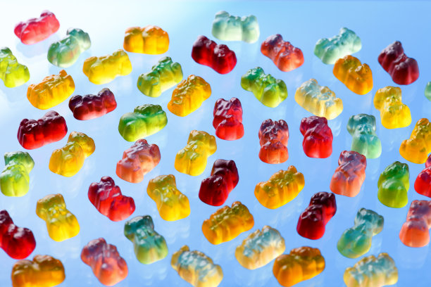 蓝色背景上的彩色飞行小熊软糖图片下载