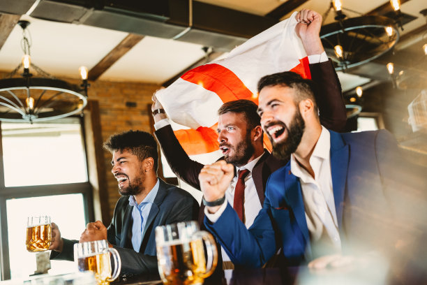 男球迷在电视上尖叫着看足球比赛，在酒吧里喝啤酒图片下载