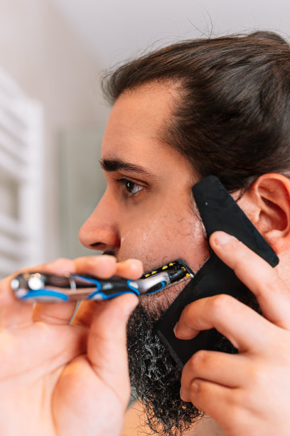 留着长胡子的年轻人，用安全剃刀刮胡子图片下载
