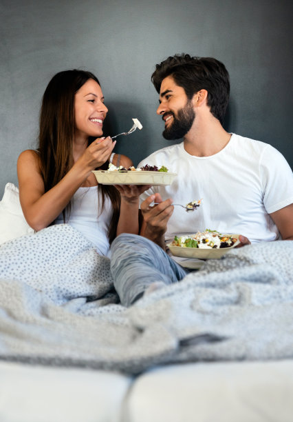 浪漫幸福的情侣在床上吃早餐图片下载