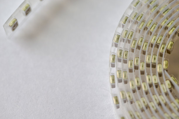 微电子产业的概念。带有贴片或表面贴装电感元件的胶带在白色胶带上的特写。图片下载