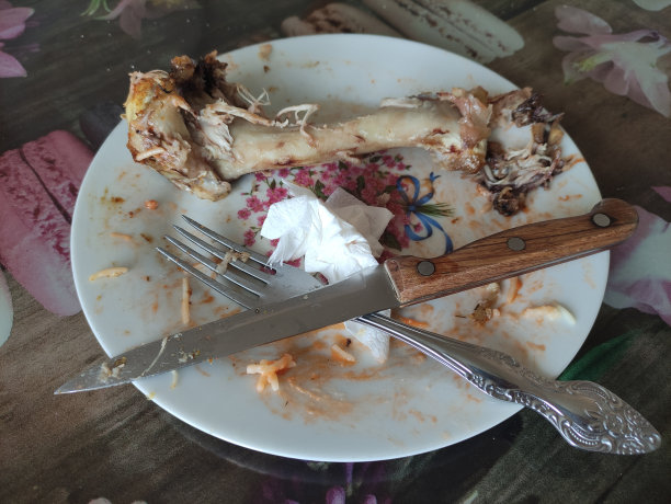 盘子里放着吃剩的食物，火鸡骨头和刀叉图片下载