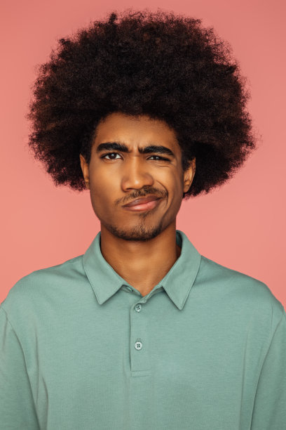 留着非洲发型的非裔美国人站在孤立的粉红色背景上图片下载