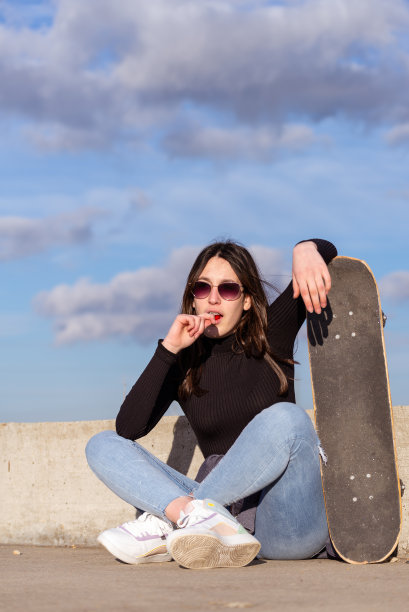 年轻女孩坐在户外休息。图片下载