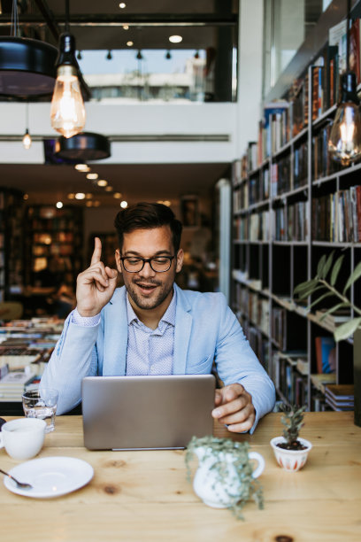 有魅力的男人在书店用笔记本电脑图片下载