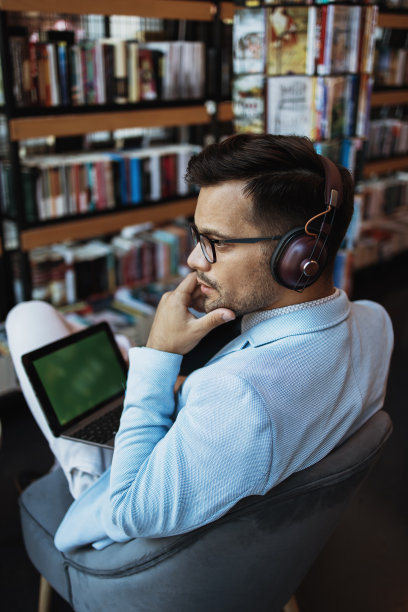 有魅力的男人在书店用笔记本电脑图片下载