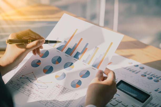 会计人员处理商业报告中所计算的数据表。办公室里有台笔记本电脑图片下载