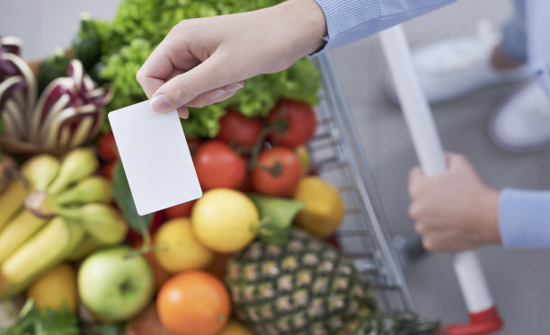 推着手推车，拿着一张空白卡片的女人图片下载