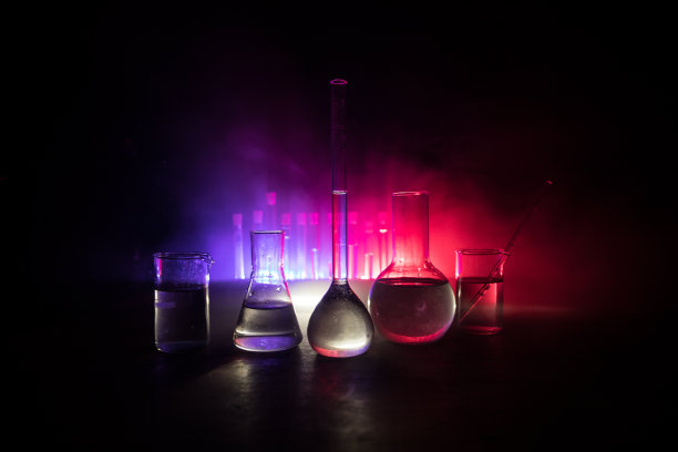 在实验室用溶液测试玻璃烧瓶。科学和医学背景。实验室试管暗色调背景，科研设备概念图片下载