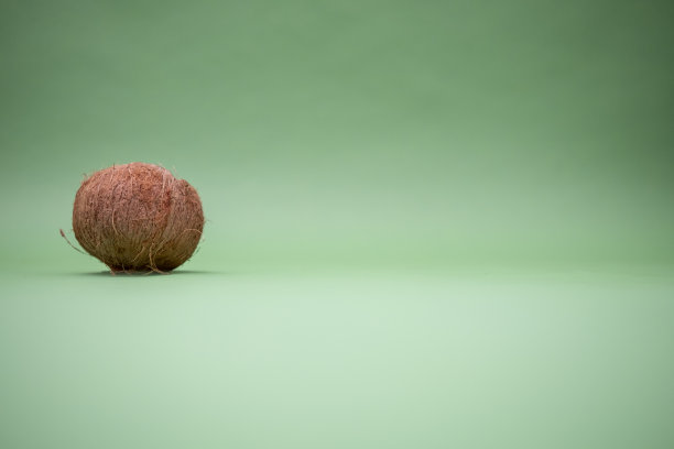 绿色背景上的椰子。绿松石色背景的热带水果。整个图片下载