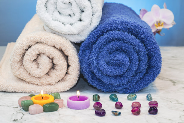 在花岗岩底座上，毛巾卷着蜡烛和彩石图片下载