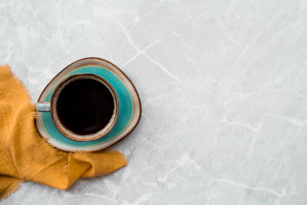 咖啡馆和餐馆。一杯充满活力的黑咖啡，一条毛巾，灰色大理石背景。铭文的位置。热饮的概念。图片下载