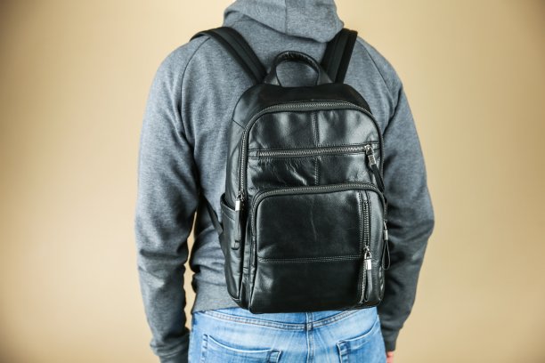 男子穿着休闲服装与皮革双肩包工作室照片拍摄图片下载