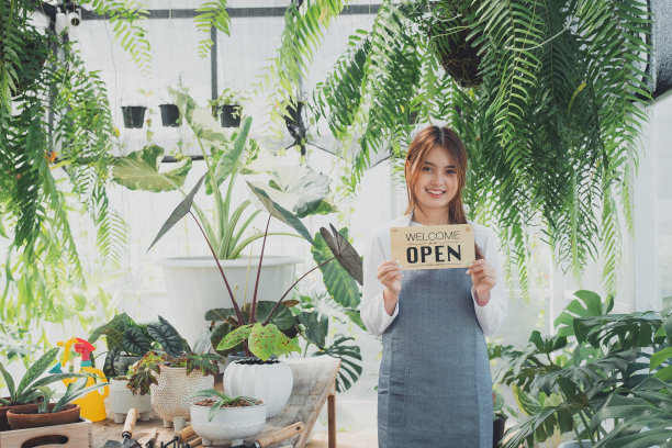 店主站在街市摊位上，心情愉快。图片下载