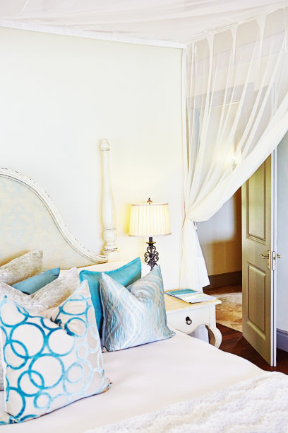时髦的卧室，双人床上有蚊帐和许多大靠垫图片下载