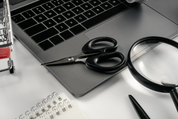 笔记本电脑，放大镜，剪刀，购物车和笔记本电脑的白色背景板图片下载