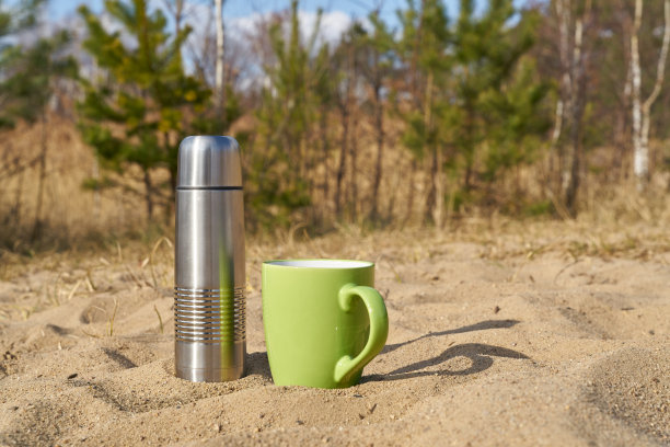 在大自然中与热水瓶和杯子野餐图片下载