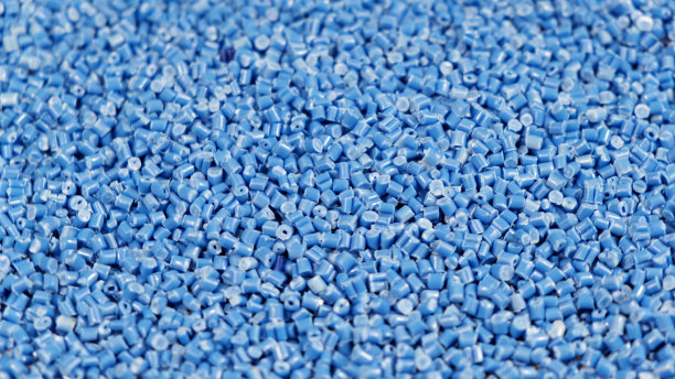 二次颗粒由聚丙烯制成，蓝色塑料颗粒碎落在桌子上。工业用塑料颗粒原料。聚合物树脂。原塑料回收概念图片下载