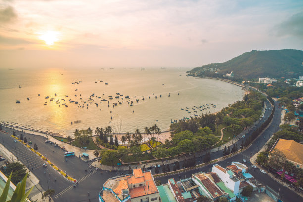 鸟瞰头市，有美丽的日落和许多船只。全景的沿海Vung Tau的看法，从上面，海浪，海岸线，街道，椰子树和陶凤山在越南。图片下载