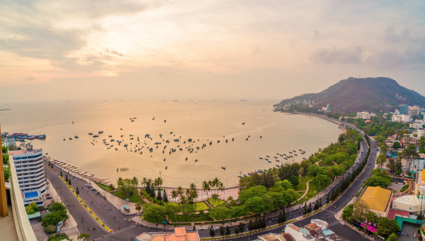 鸟瞰头市，有美丽的日落和许多船只。全景的沿海Vung Tau的看法，从上面，海浪，海岸线，街道，椰子树和陶凤山在越南。图片下载